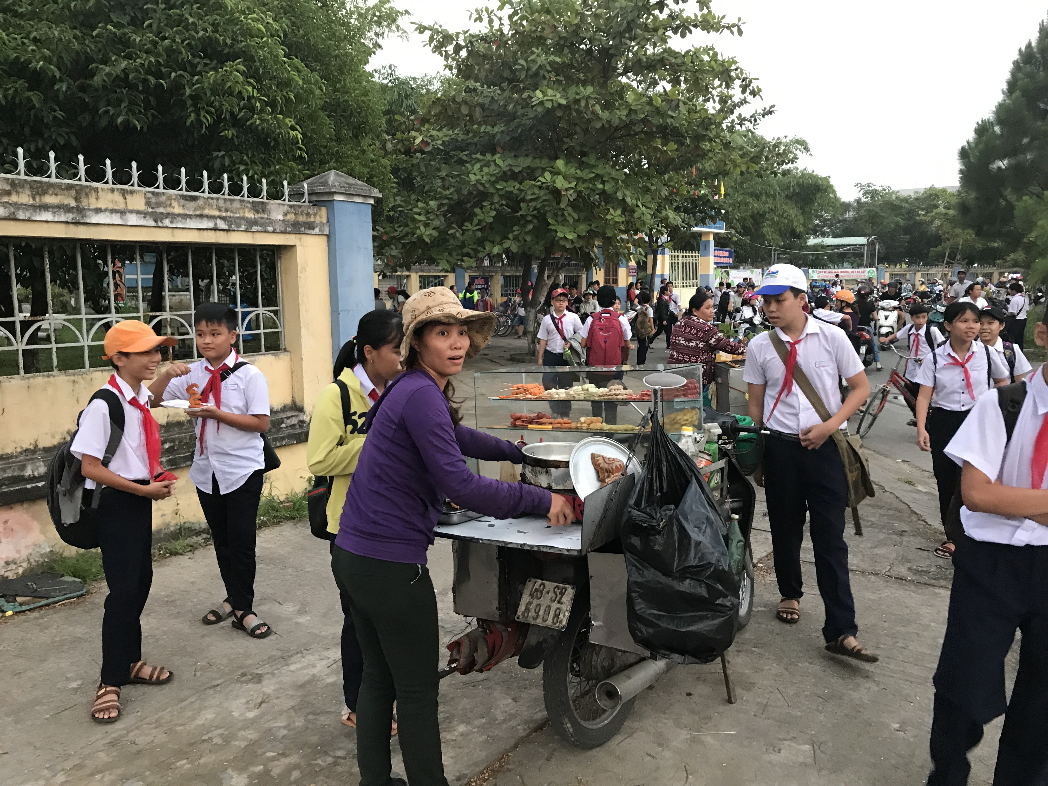 Nice woman selling street food outside of a school in Vietnam.