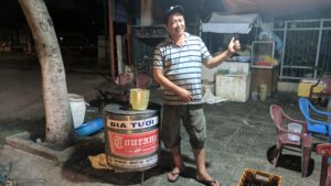 Vietnamese man sets up his restaurant on the sidewalk in Danang.