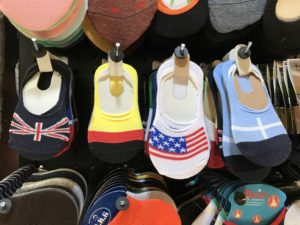 Seen in the Kermanshah Bazaar. From left to right: baby socks with the flags of Britain, Germany, America, and Greece (although, I could be wrong about the Greece flag). Pictures of the American flag inside Iran - and United States military merchandise, too! | VincePerfetto.com